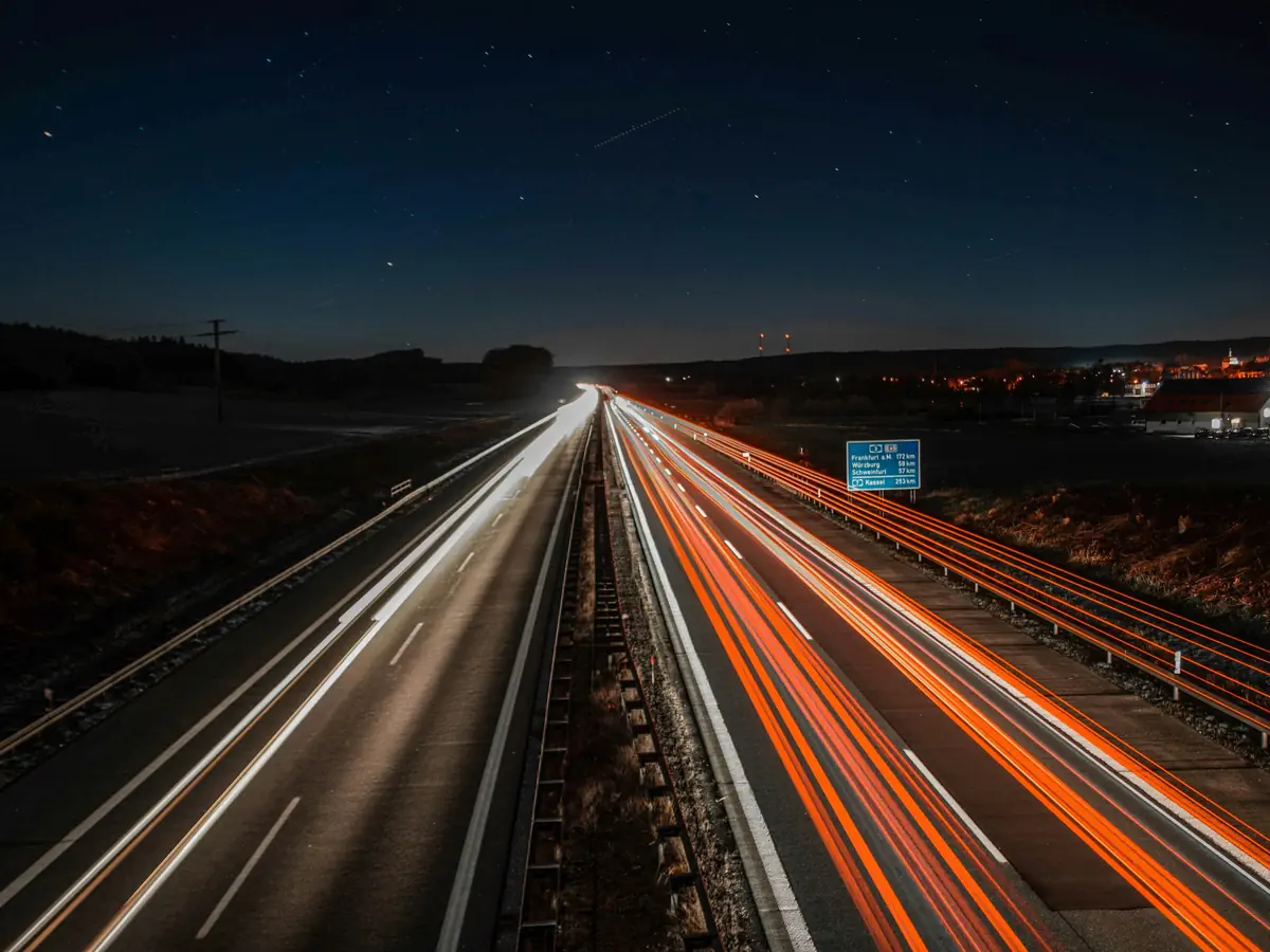 Autostrada nocą, światła aut w ruchu. Nasze stałe kierunki: Austria, Słowenia, Chorwacja, Rumunia, Litwa, Łotwa i Finlandia.
